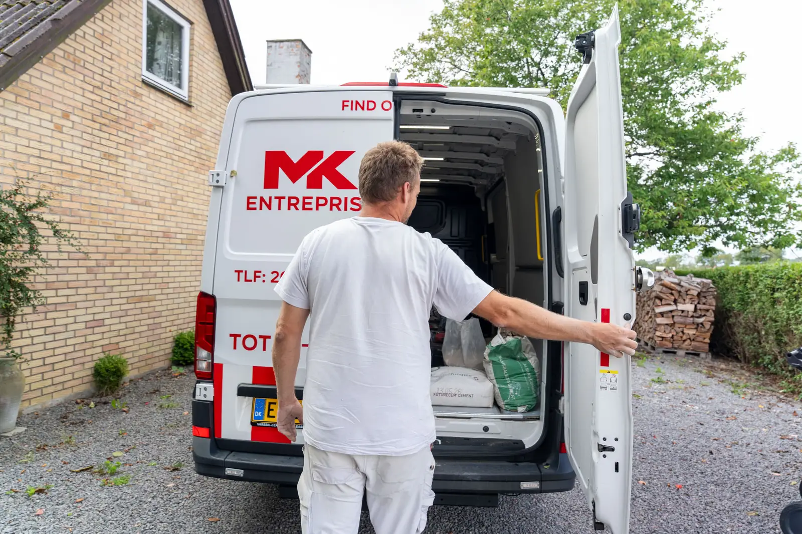 Medarbejder henter materiel i MK Entreprises firmabil på opgaven