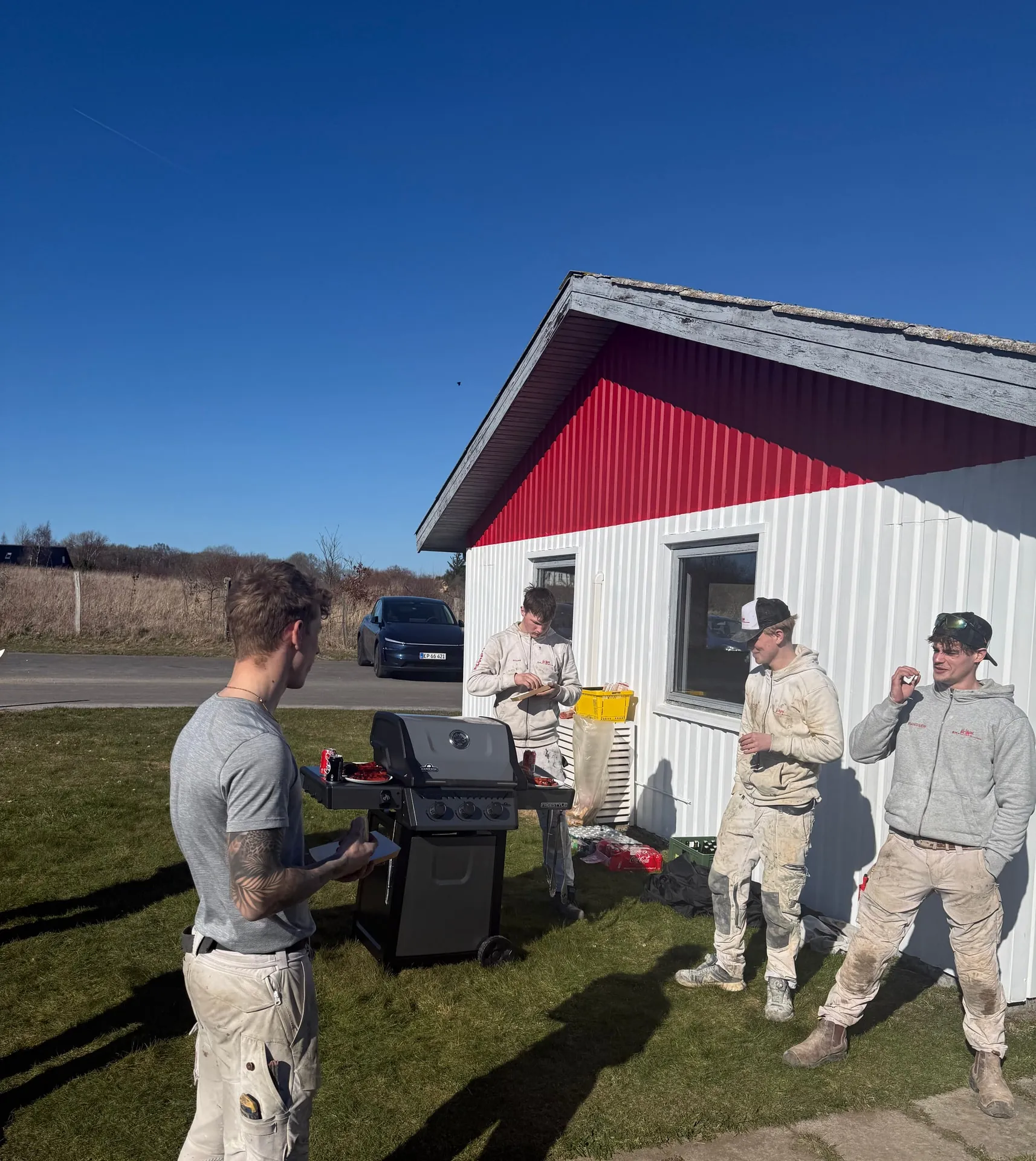 Kollegaer fra MK Entreprise samlet om grillen på pladsen