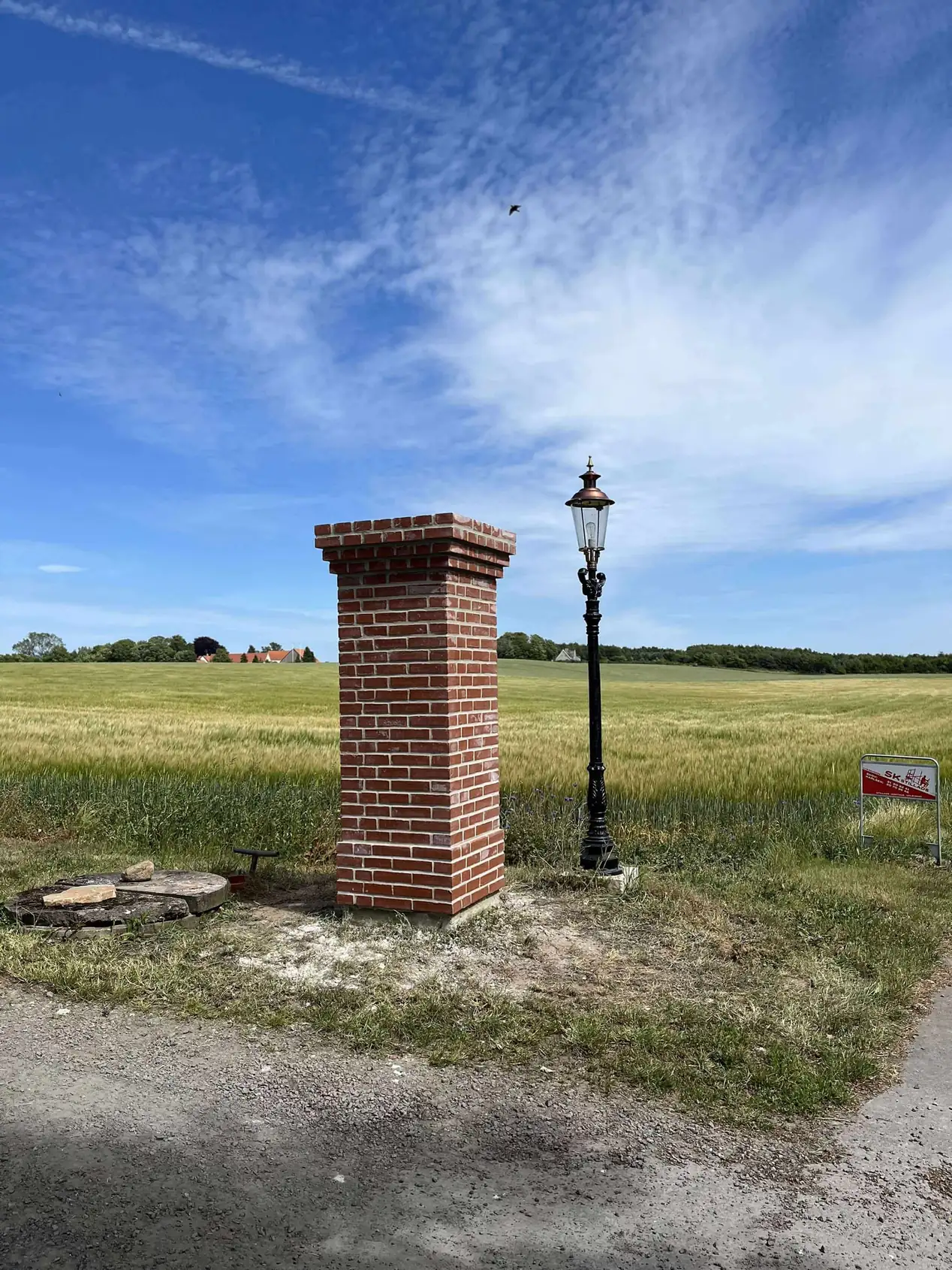 Muret indkørselspille i røde sten med afdækning